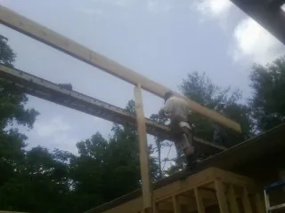 Carpenter setting a ridge beam over a new addition frame — Ice Dam Removal by Roofing Brothers in Mount Gretna