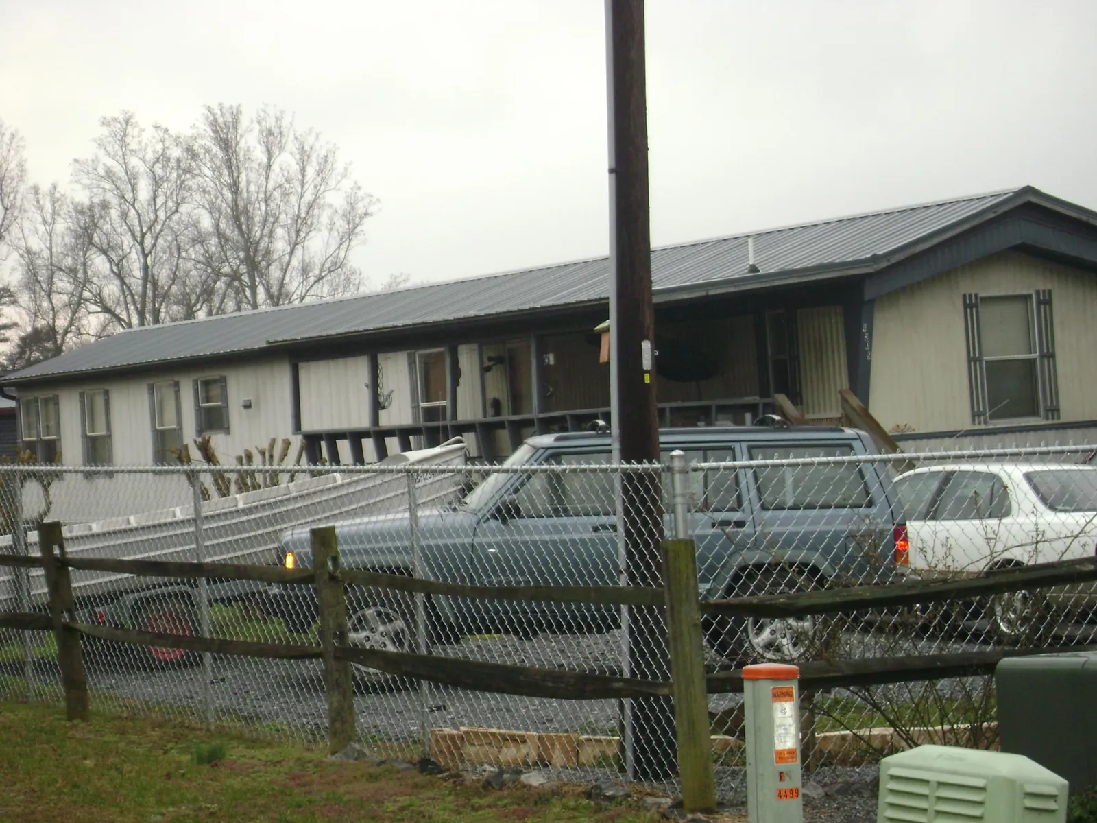 Dark metal roof on a long single story building behind a chain link fence in Mount Gretna