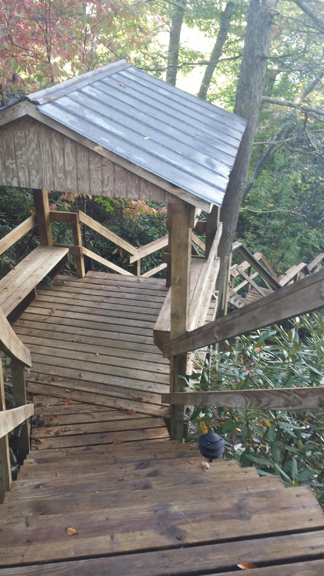 Metal roofed shelter over wooden steps on a wooded walkway — Skylight Repair & Installation work by our crew in Mount Gretna